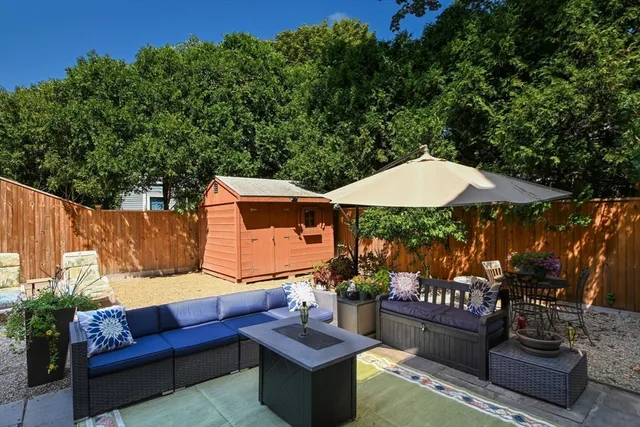 an outdoor sitting area with furniture and umbrella
