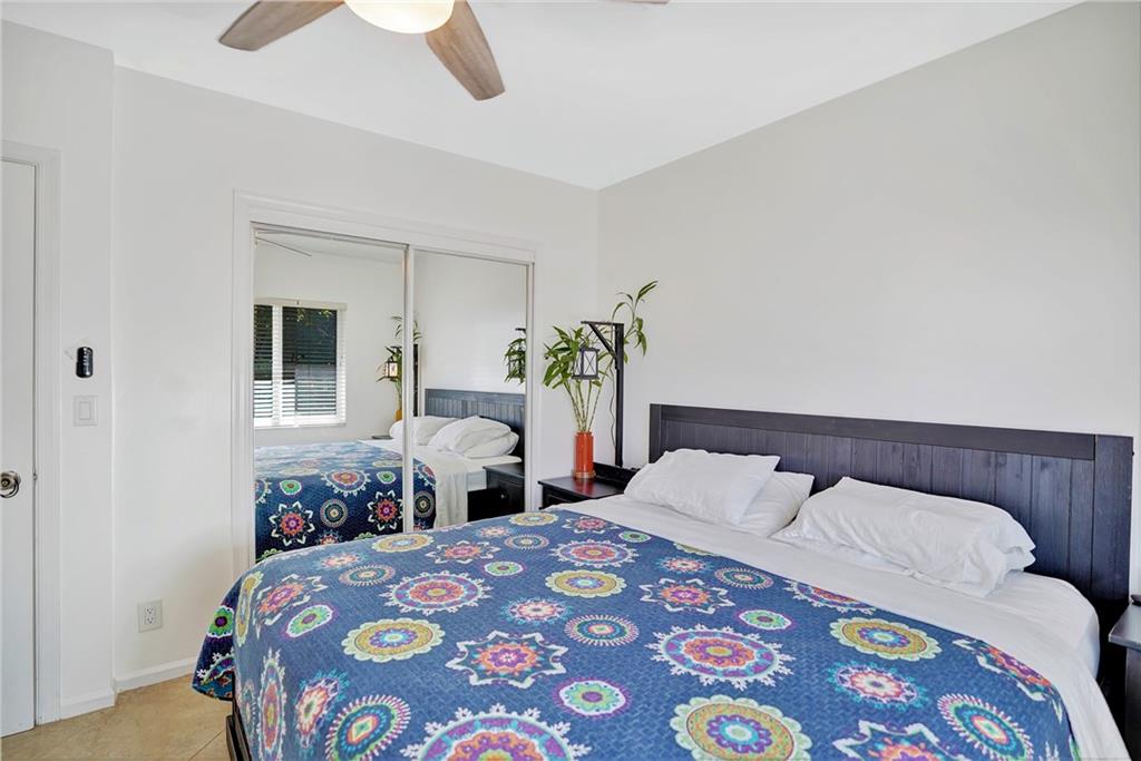 5700 Northeast 22nd Way, Unit 322 Fort Lauderdale, FL 33308 - Photo 13 of 19 a bedroom with a bed and a chandelier