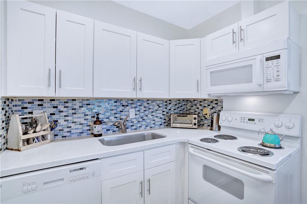 5700 Northeast 22nd Way, Unit 322 Fort Lauderdale, FL 33308 - Photo 3 of 19 a kitchen with white cabinets and white appliances