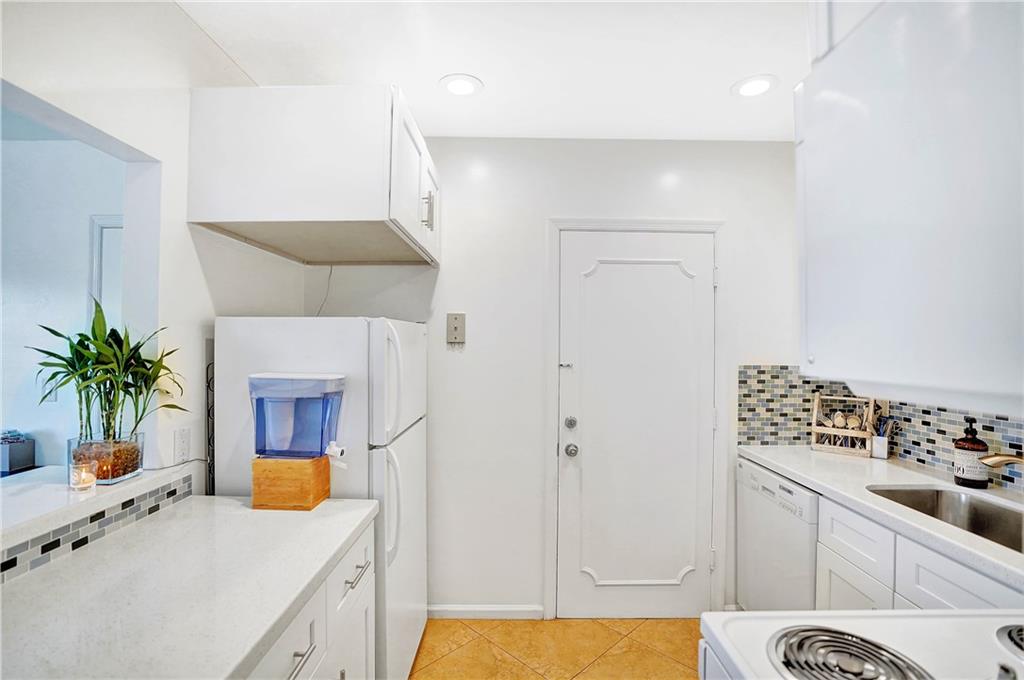 5700 Northeast 22nd Way, Unit 322 Fort Lauderdale, FL 33308 - Photo 4 of 19 a kitchen with stainless steel appliances a sink a refrigerator a counter space and a view of living room