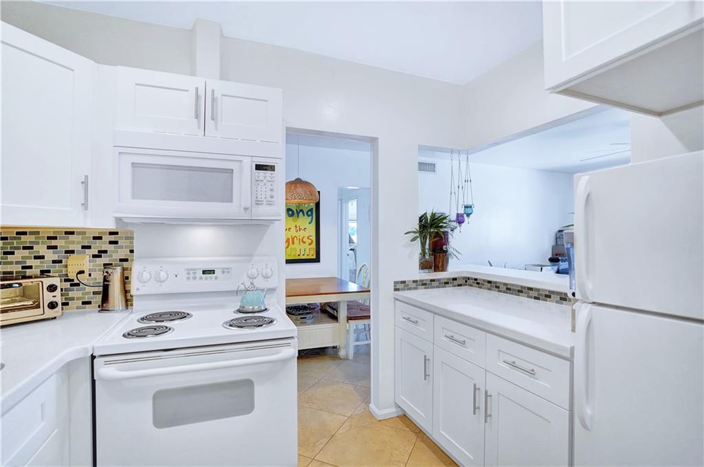 5700 Northeast 22nd Way, Unit 322 Fort Lauderdale, FL 33308 - Photo 6 of 19 a kitchen with white cabinets and white appliances