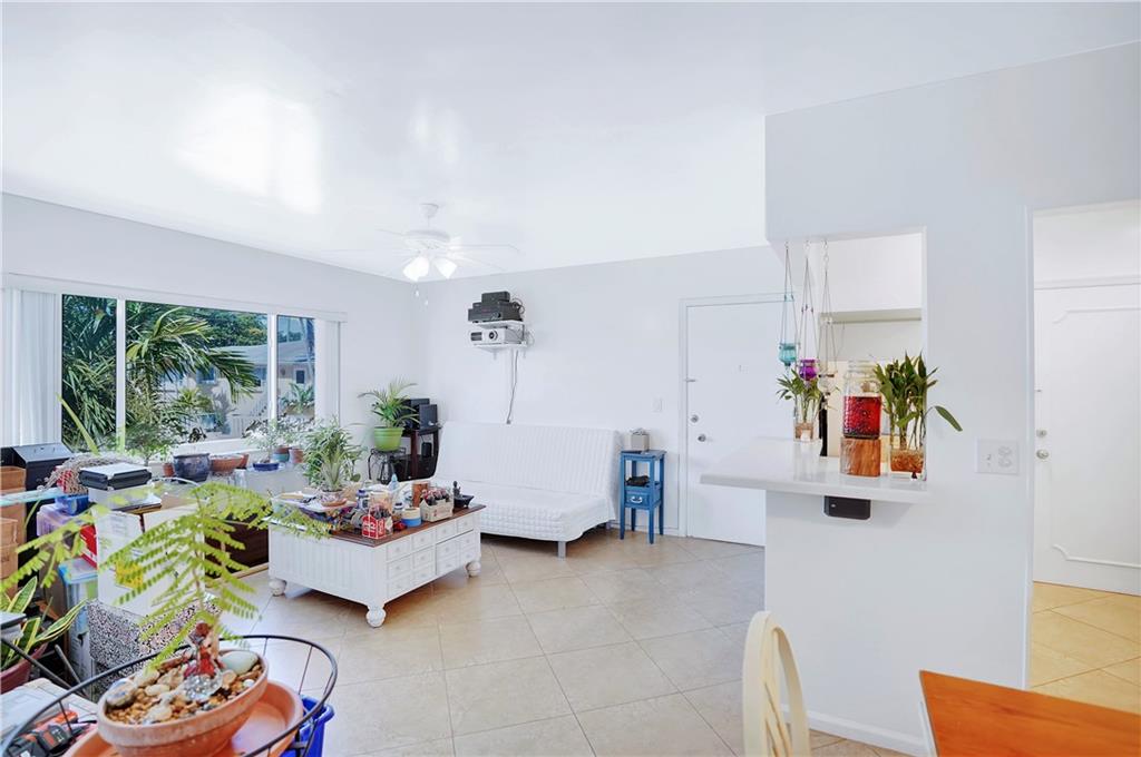 5700 Northeast 22nd Way, Unit 322 Fort Lauderdale, FL 33308 - Photo 9 of 19 a living room with furniture and a floor to ceiling window