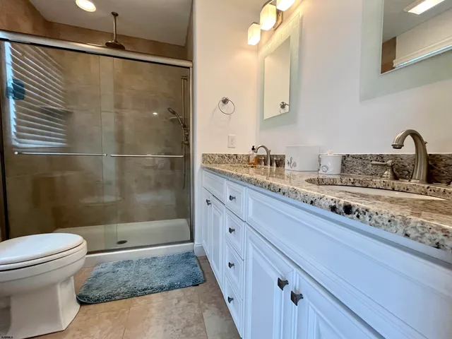 a bathroom with a sink a toilet and shower