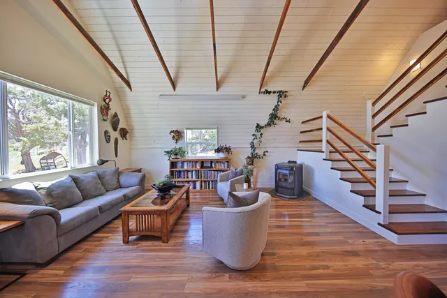 a kitchen with stainless steel appliances kitchen island granite countertop a table chairs in it and wooden floors