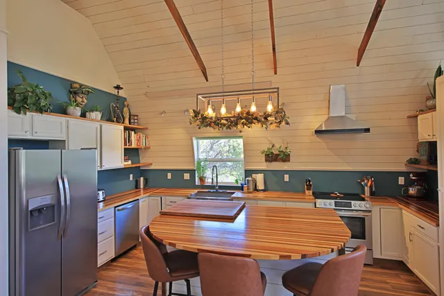 a dining room with stainless steel appliances kitchen island granite countertop furniture and wooden floor