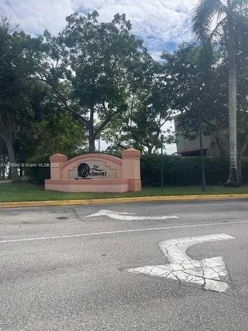 a view of a house with a yard and large tree