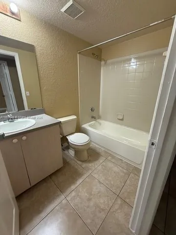 a bathroom with a granite countertop sink toilet a mirror and shower