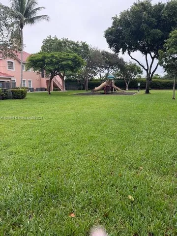 a view of a field of grass and trees