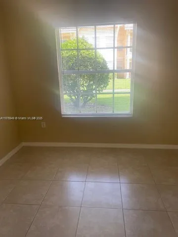 a view of a livingroom with an empty space and a window