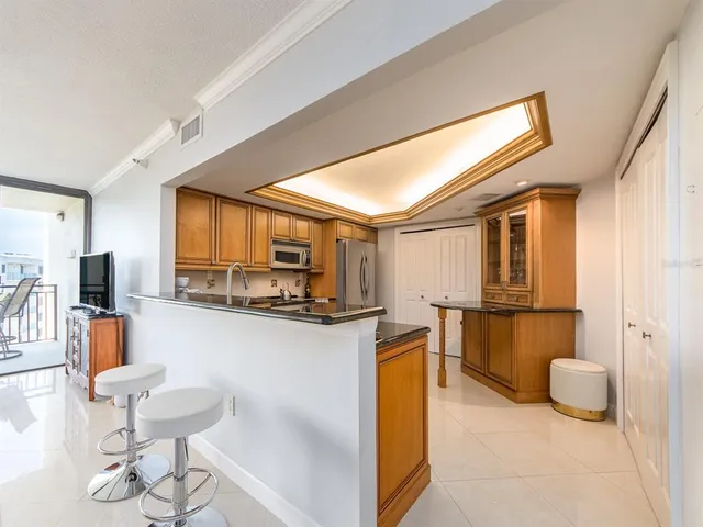 a kitchen with stainless steel appliances kitchen island granite countertop a table and chairs in it