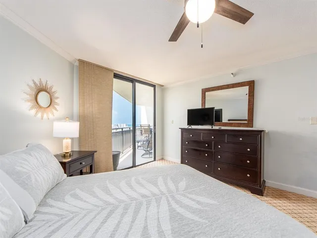 a bedroom with a bed and a flat tv screen on dresser