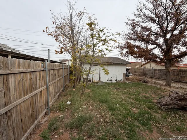 a backyard of a house with wooden floor table and chairs
