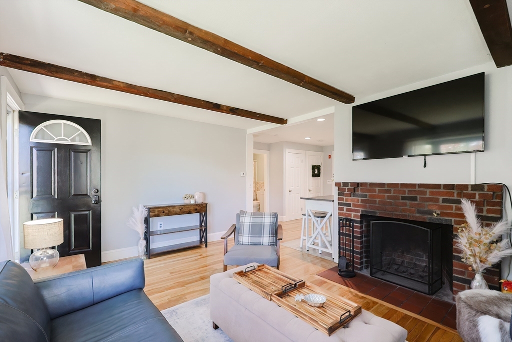 321 Shears Street Wrentham, MA 02093 - Photo 11 of 39 a living room with furniture a flat screen tv and a fireplace