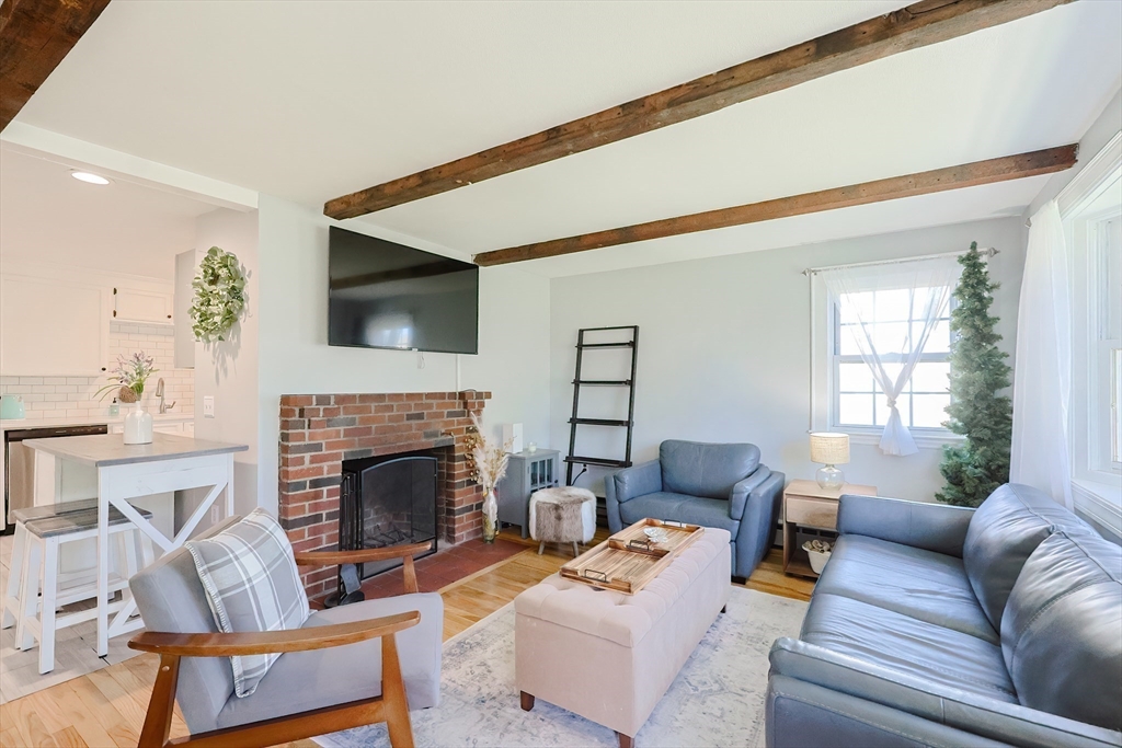 321 Shears Street Wrentham, MA 02093 - Photo 10 of 39 a living room with furniture a fireplace and a flat screen tv