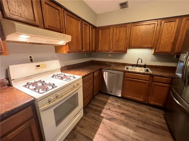 a kitchen with a stove sink and cabinets
