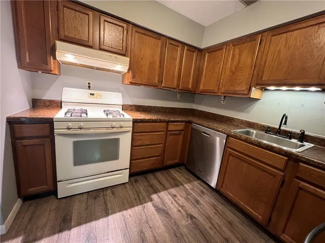 a kitchen with a sink a stove and cabinets
