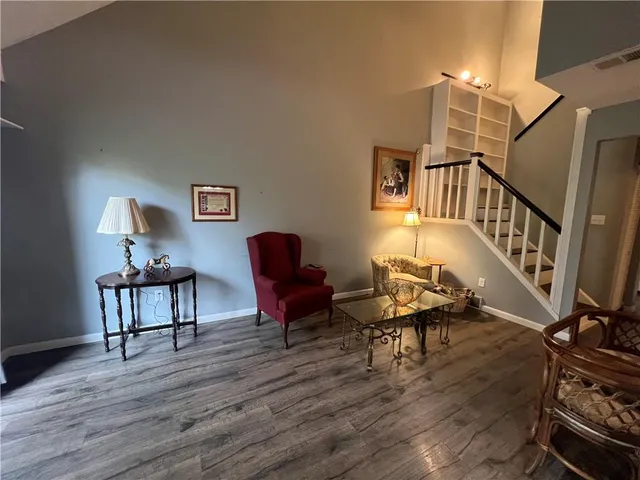 a view of a workspace with furniture a rug and wooden floor