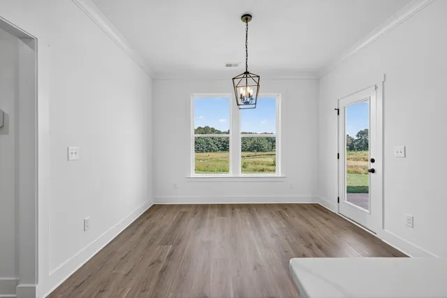 a view of empty room with wooden floor and window