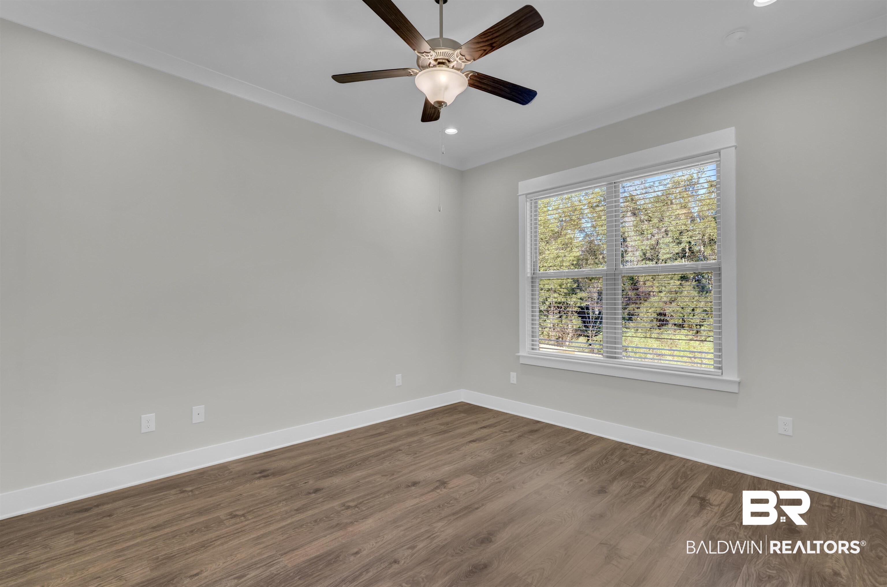 571 Morning Mist Way Fairhope, AL 36532 - Photo 21 of 47 Empty room with dark wood finished floors, recessed lighting, crown molding, and a ceiling fan