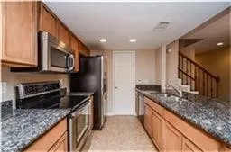 a kitchen with stainless steel appliances granite countertop a sink stove and refrigerator