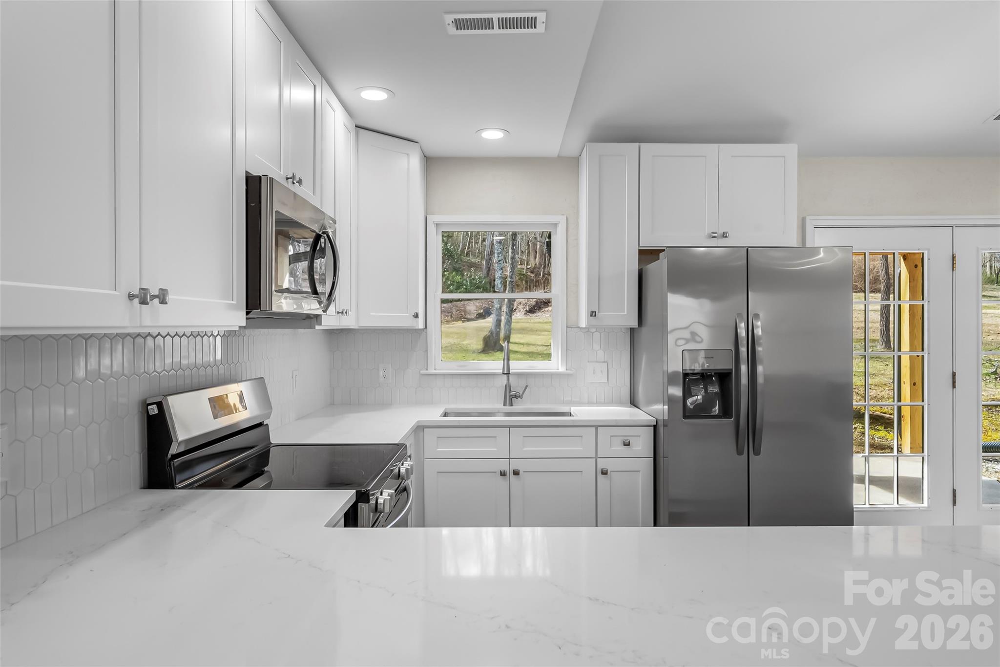 99 Hawkins Road Marion, NC 28752 - Photo 12 of 39 a kitchen with stainless steel appliances a refrigerator a sink a stove and cabinets