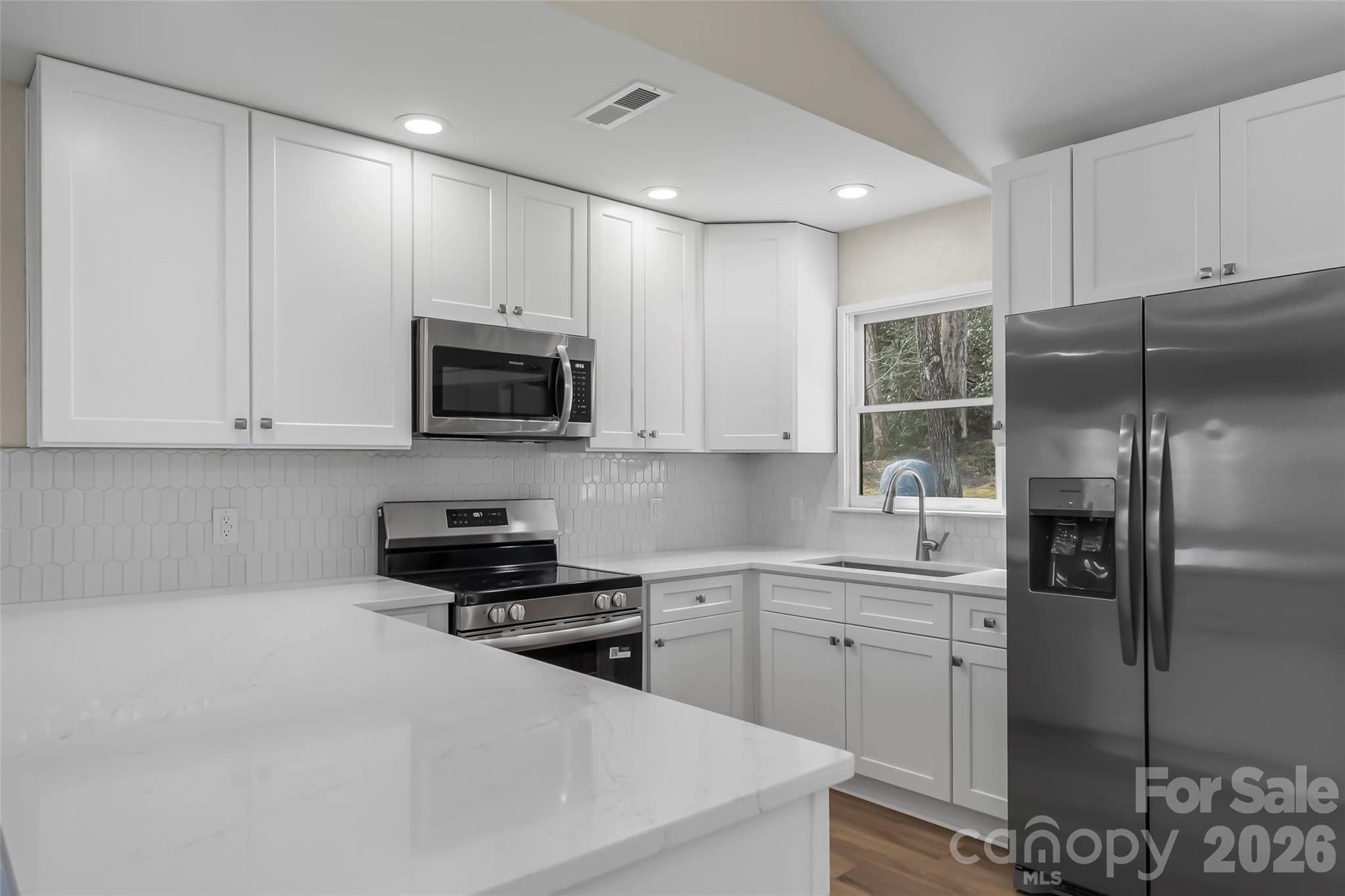 99 Hawkins Road Marion, NC 28752 - Photo 9 of 39 a kitchen with stainless steel appliances granite countertop a refrigerator a sink a stove a microwave and cabinets