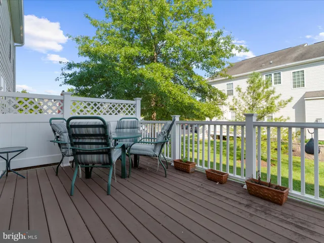 a view of a roof deck with table and chairs and wooden floor
