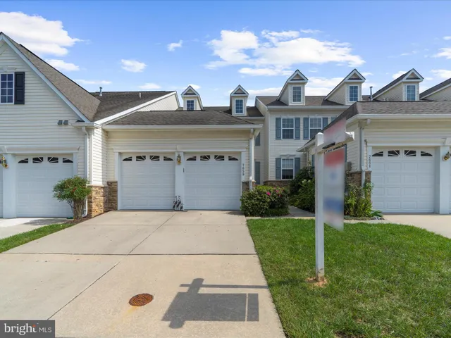 a view of a house with a yard and potted plants
