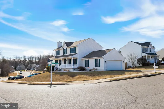 a view of a house with a big yard and large trees