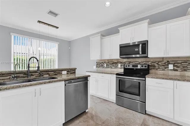 a kitchen with stainless steel appliances granite countertop a sink stove oven a sink and dishwasher a refrigerator with wooden cabinets