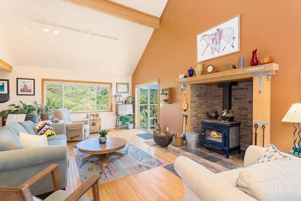 a living room with furniture a fireplace and large windows