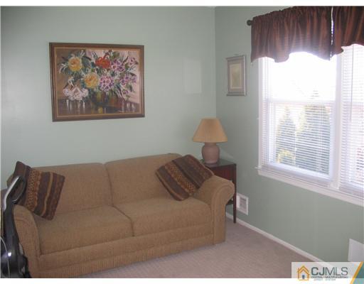 6 Sinclair Road Edison, NJ 08820 - Photo 14 of 14 a blue couch sitting in a bedroom next to a window