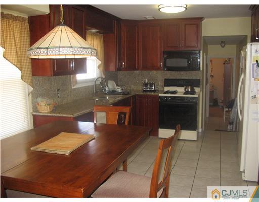 6 Sinclair Road Edison, NJ 08820 - Photo 5 of 14 a kitchen with a sink a stove and a microwave