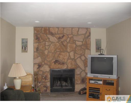 6 Sinclair Road Edison, NJ 08820 - Photo 9 of 14 a room with a fireplace and a flat screen tv