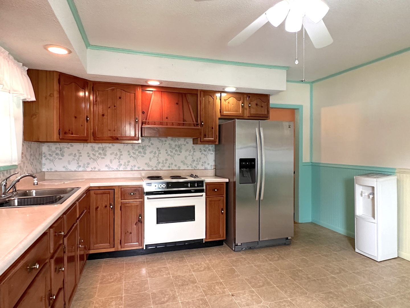 106 George Street Hurst, IL 62949 - Photo 5 of 14 a kitchen with stainless steel appliances a sink a stove a refrigerator cabinets and a dining table
