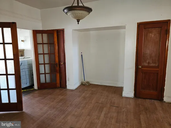 an empty room with chandelier fan and windows
