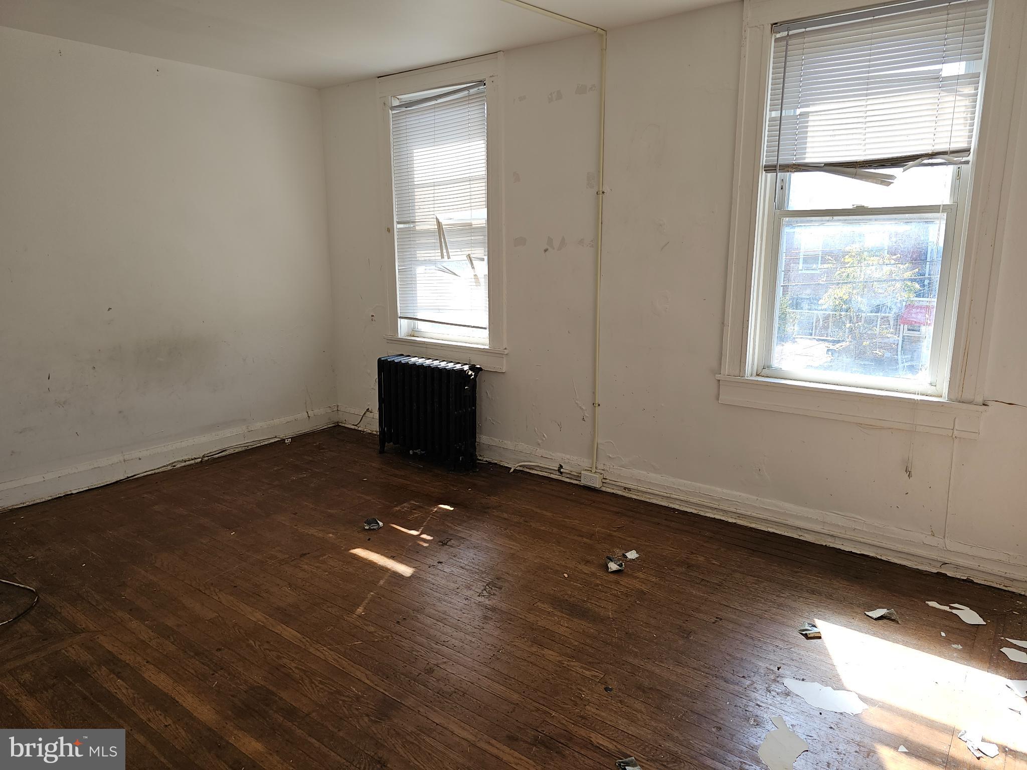 3239 Dudley Avenue Baltimore, MD 21213 - Photo 19 of 31 an empty room with wooden floor and windows