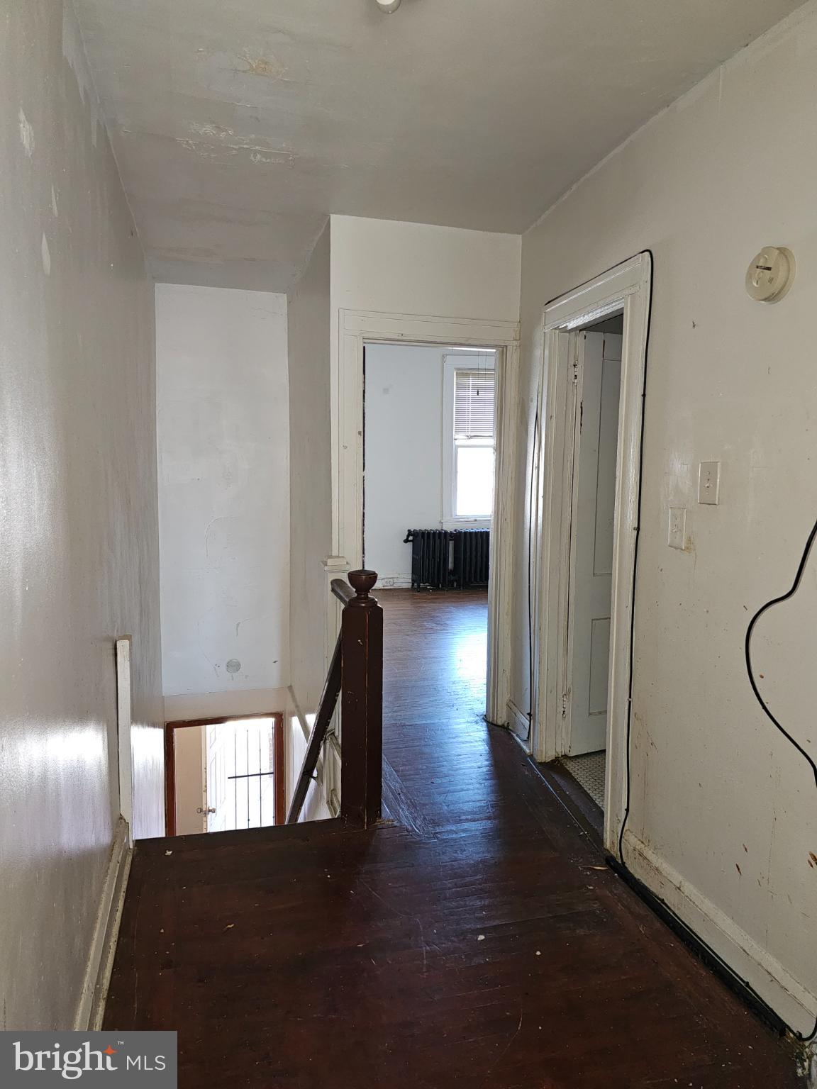 3239 Dudley Avenue Baltimore, MD 21213 - Photo 21 of 31 a view of a hallway with wooden floor and a living room