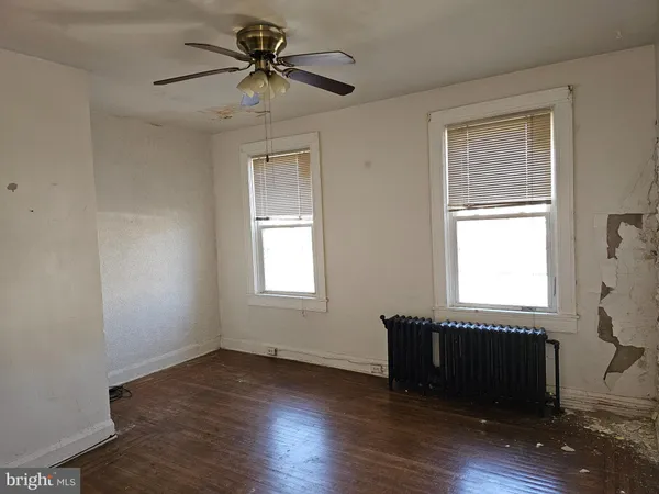 a view of an empty room with a window and a dresser