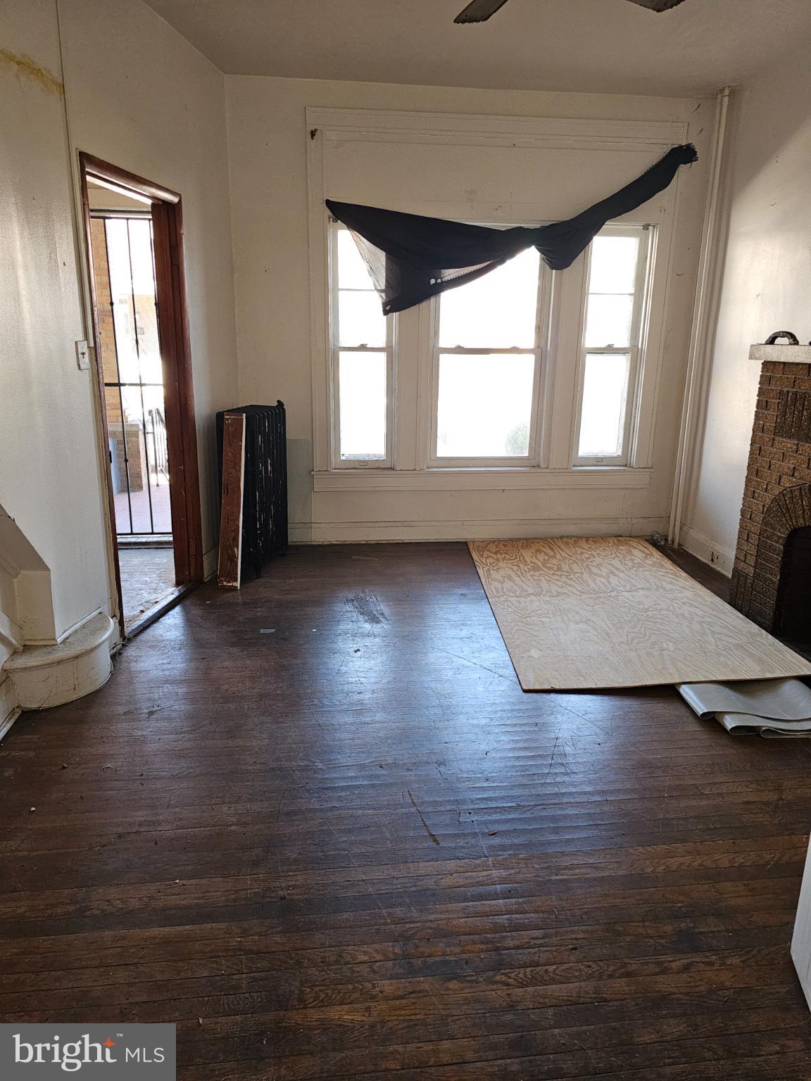 3239 Dudley Avenue Baltimore, MD 21213 - Photo 7 of 31 an empty room with wooden floor and windows