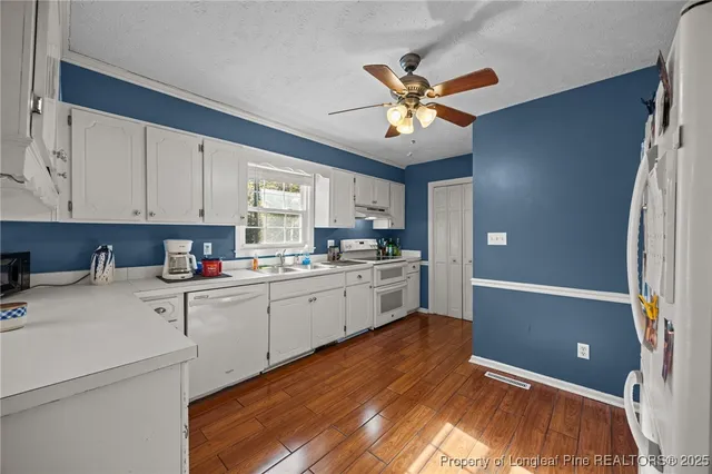 a kitchen with cabinets appliances a sink and a window