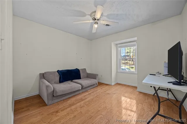 an empty room with a window and a fan