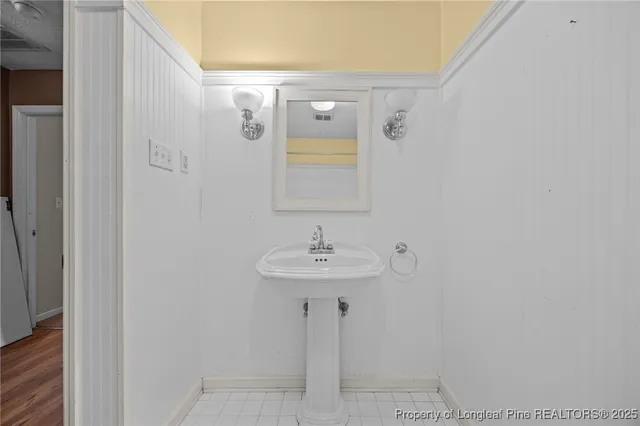 a view of an empty room and chandelier fan