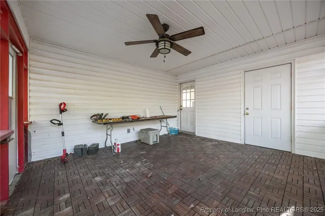 a view of a small house with large trees and a small barn