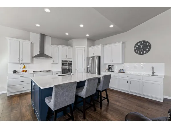 a kitchen with a dining table chairs and refrigerator