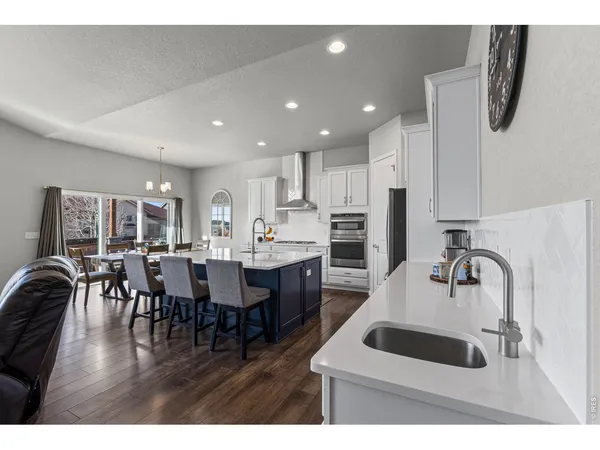 a kitchen with kitchen island granite countertop a sink and white cabinets