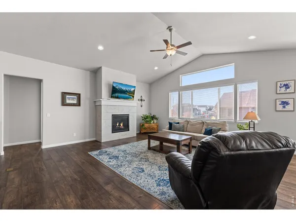 a living room with furniture a large window and a fireplace
