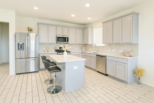 a kitchen with stainless steel appliances kitchen island granite countertop a sink and cabinets