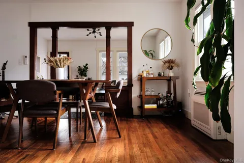 a dining room with furniture a large window and wooden floor