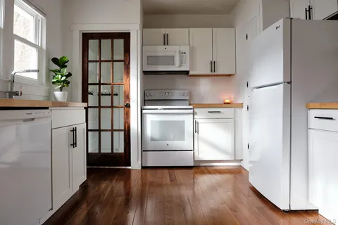 a kitchen with stainless steel appliances a stove a refrigerator and a hard wood floor